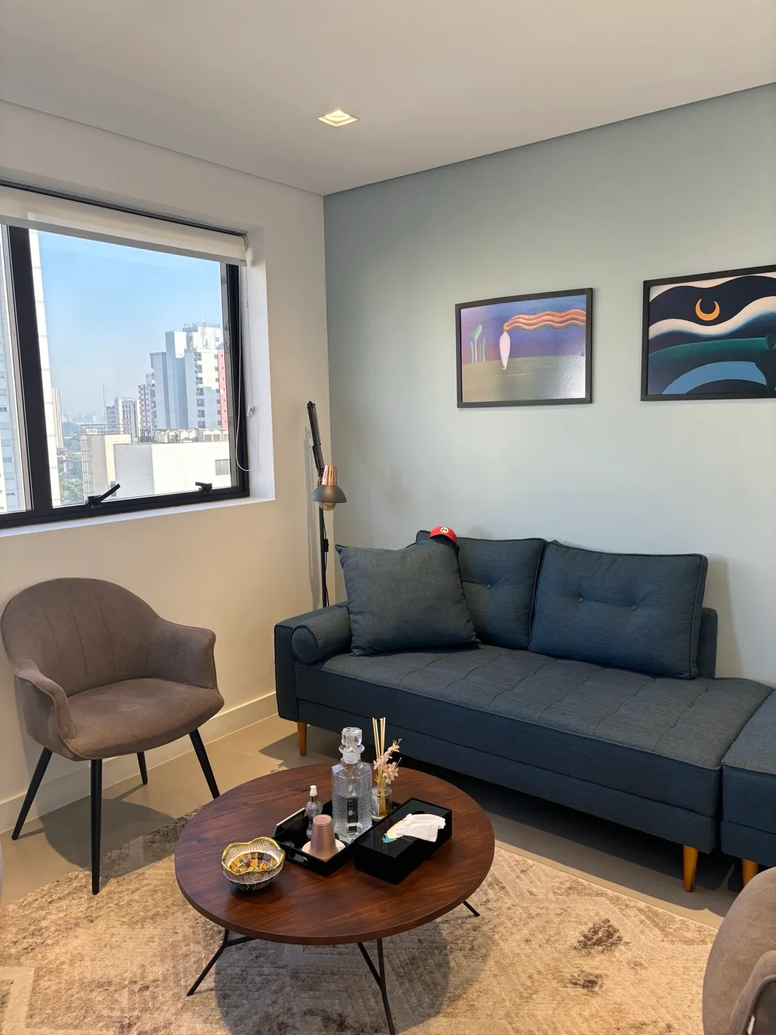 Consultório de Ana Stella — poltronas, mesa de centro e vista de janela